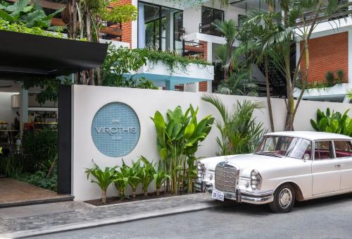 an old white car parked in front of a building at Viroth's Villa in Siem Reap