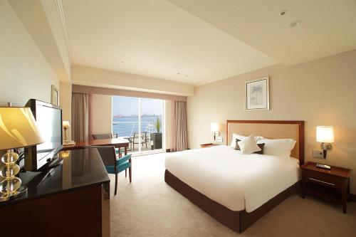 a hotel room with a bed and a large window at Kobe Meriken Park Oriental Hotel in Kobe