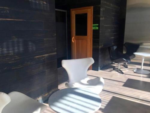 a room with two white chairs and a door at Quartier Dorrego in Buenos Aires
