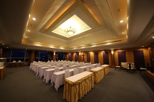 a banquet hall with white tables and chairs and a ceiling at Sunshine Vista Hotel in Pattaya Central