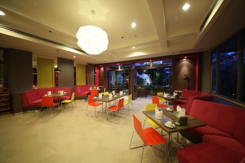 a restaurant with red furniture and tables and chairs at Sunshine Vista Hotel in Pattaya Central