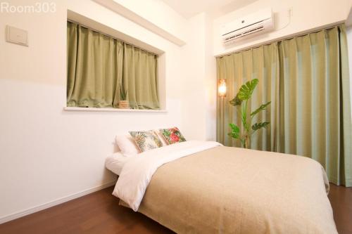 um quarto com uma cama e uma janela em La Fonte UK2 em Ginowan