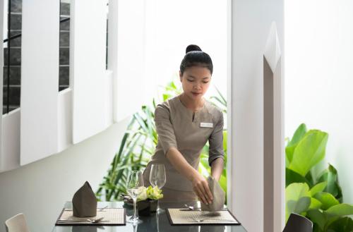 a woman standing at a table in a restaurant at Viroth's Villa in Siem Reap