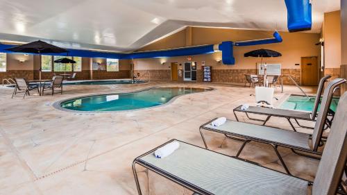 a pool in a hotel room with tables and chairs at Best Western Plus Blaine at the National Sports Center in Blaine