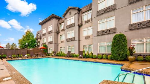 a swimming pool in front of a building at Best Western Plus Pitt Meadows Inn & Suites in Pitt Meadows