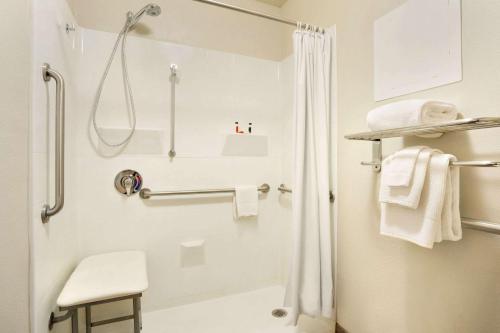 y baño blanco con ducha y aseo. en Travelodge by Wyndham Winslow, en Winslow