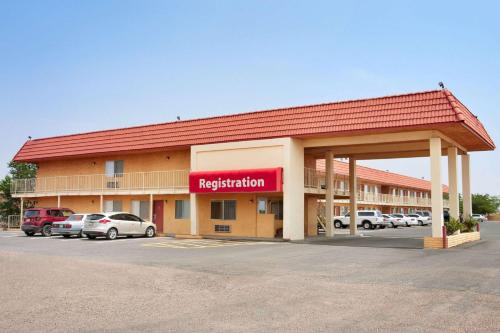 a hotel with cars parked in a parking lot at Travelodge by Wyndham Winslow in Winslow