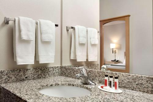 bagno con lavandino, specchio e asciugamani di Travelodge by Wyndham Milford a Milford