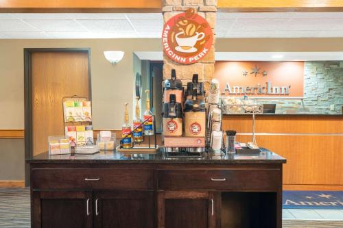 a counter in a coffee shop with bottles on it at AmericInn by Wyndham Coon Rapids in Coon Rapids