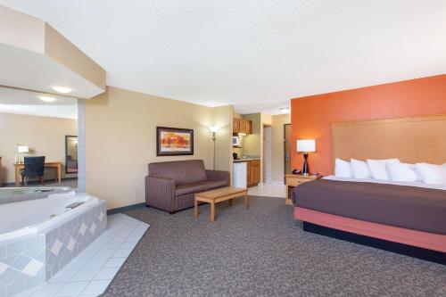una habitación de hotel con una cama y una bañera en AmericInn by Wyndham Boscobel, en Boscobel
