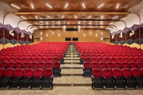 an empty auditorium with red chairs and a stage at Ramada Plaza by Wyndham Rize in Rize