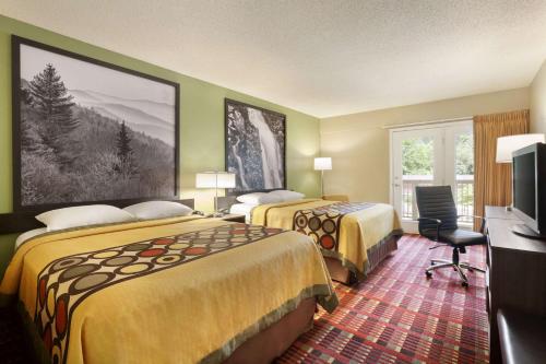 a hotel room with two beds and a television at Super 8 by Wyndham Cherokee in Cherokee