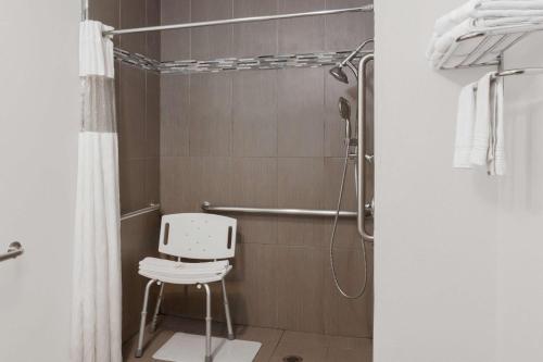 a shower with a white chair in a bathroom at Super 8 by Wyndham Santa Clarita/Valencia in Santa Clarita