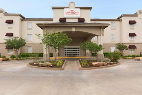 a front view of a hotel with a parking lot at Hawthorn Extended Stay by Wyndham College Station in College Station