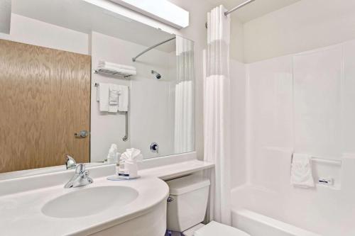 夏安的住宿－夏安麥克羅特客棧&套房，白色的浴室设有水槽、浴缸和卫生间。
