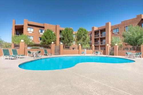 a swimming pool with chairs and tables in front of a building at Super 8 by Wyndham Page/Lake Powell in Page