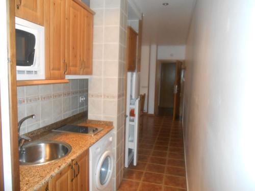 a kitchen with a sink and a washing machine at Villa Maria in La Virgen de la Vega