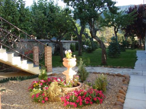 a garden with a vase and flowers in a yard at Posada del Indiano in Cidones