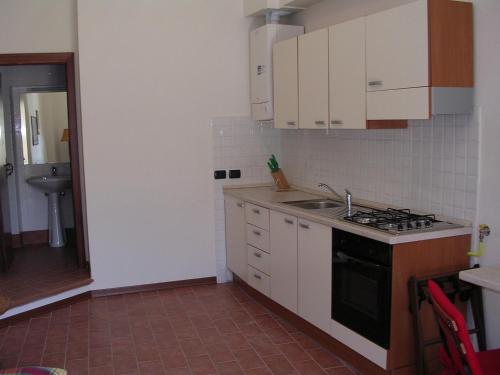 a small kitchen with white cabinets and a sink at Casa Vacanze Del Pescatore in Passignano sul Trasimeno