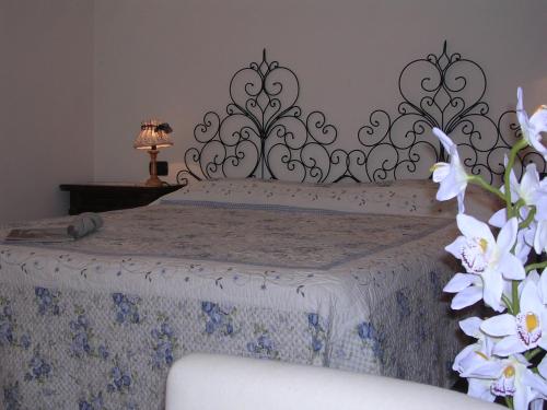 a bedroom with a bed with a bedspread and flowers at Casa Vacanze Del Pescatore in Passignano sul Trasimeno