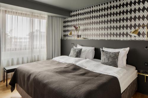 a bedroom with a large bed and a large window at Original Sokos Hotel Presidentti Helsinki in Helsinki