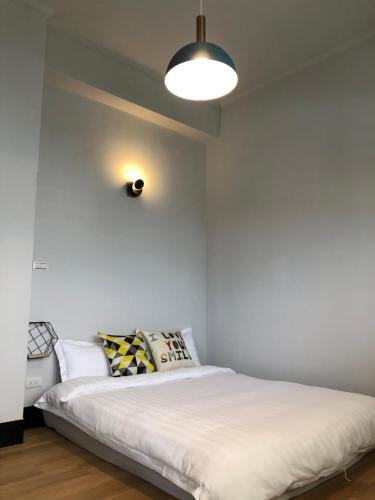 a bedroom with a large white bed with a lamp at 湘品旅店Xiang Pin Hotel-東大門夜市-無電梯無電視 -花蓮縣旅館065號 in Hualien City