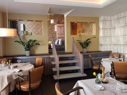 a restaurant with tables and chairs and a staircase at De Eenhoorn in Oostburg
