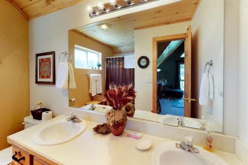 a bathroom with two sinks and a large mirror at Painted Pony Cabin in Angel Fire
