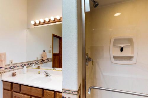 a bathroom with a sink and a shower and a mirror at Snowfire 314A in Angel Fire
