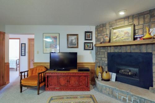 a living room with a tv and a fireplace at Snowfire 208B in Angel Fire