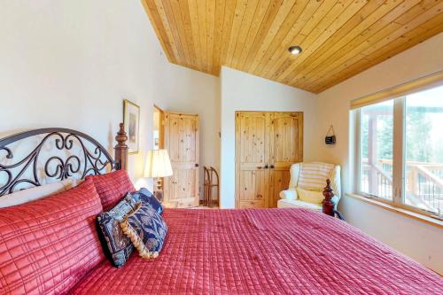 um quarto com uma cama grande e um edredão vermelho em Shalom House em Angel Fire