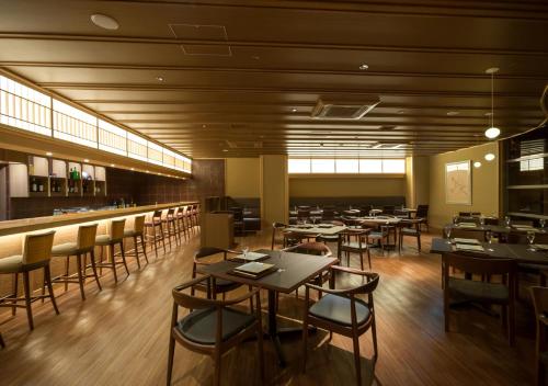 a restaurant with tables and chairs and a bar at Saka Hotel Kyoto in Kyoto