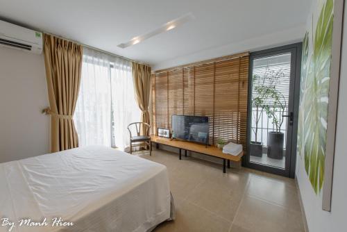 um quarto com uma cama e uma televisão num quarto em Mojzo Inn Boutique Hotel em Nha Trang