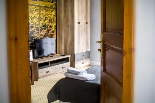 a room with a television and towels on a table at Hotel Garden in Bolesławiec