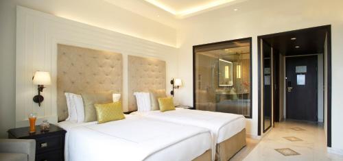 a bedroom with two large white beds in a room at Taj Ganges Varanasi in Varanasi
