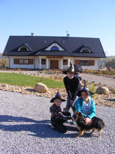 a woman and two children and a dog in front of a house at Baba Jagna in Chocimów