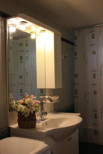a bathroom with a sink and a mirror at Mercouri stone cottage in Korakokhórion