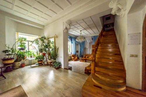 a living room with a staircase and lots of plants at Gostevoy Dom Na Rybatskoy in Ryazan