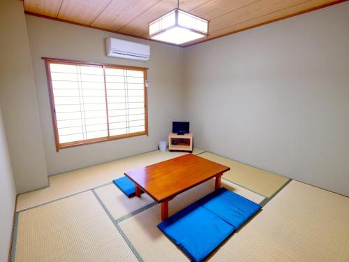 a living room with a table and blue mats at Kokumin Shukusha Sun Marina in Kaminato