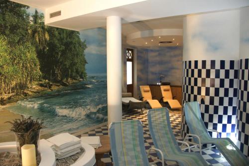 a lobby with chairs and a painting of the ocean at Hotel Post Hönigwirt in Kirchschlag