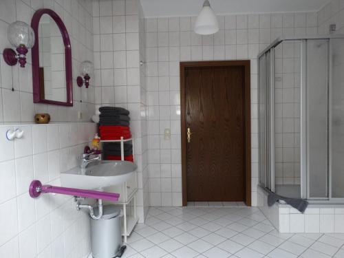 a bathroom with a sink and a mirror and a door at Ferienwohnung Franke DG RuheZeit am Schwarzwasser in Johanngeorgenstadt