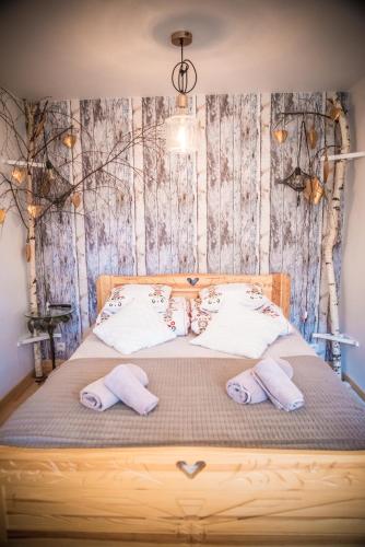 a bedroom with a bed with two towels on it at Rezydencja Sąsiadów Zakopanego in Zakopane