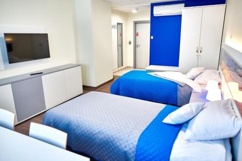 a hotel room with two beds and a tv at Hostel Umed in Łódź