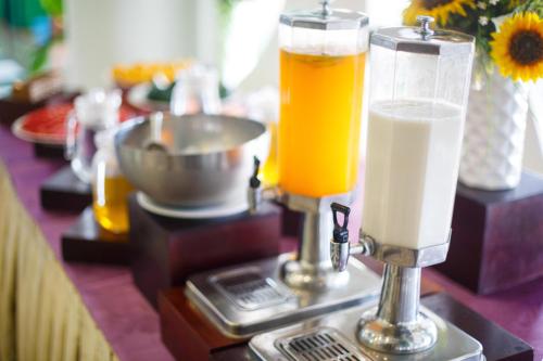 a table with two glasses of juice and drinks at Tre Xanh Hotel in Pleiku
