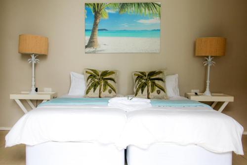 a bedroom with a bed with palm trees on it at 25 Sovereign Sands in KwaDukuza