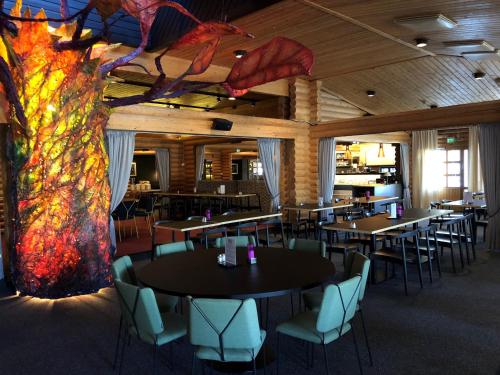 a restaurant with tables and chairs and a colorful mural at Design Hotel Levi in Levi