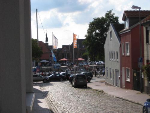 uma rua de calçada com carros estacionados numa cidade em Haus am Hafen em Neustadt in Holstein