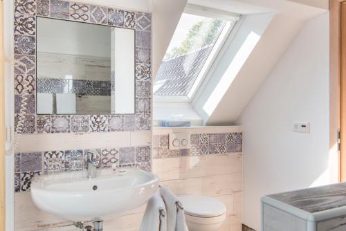 La salle de bains est pourvue d'un lavabo et d'un miroir. dans l'établissement Hotel Bellevue, à Lauenburg