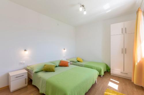 En eller flere senge i et værelse på Apartmani Bezmalinović