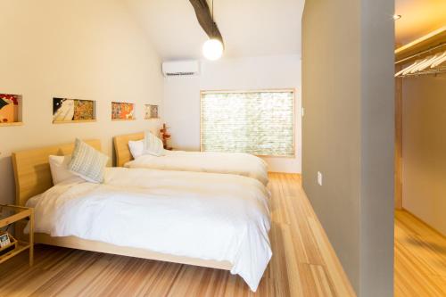 una camera da letto con due letti e una finestra di MACHIYA de HIGASHIYAMA a Kyoto